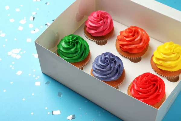 Caixa Com Deliciosos Cupcakes Coloridos Confetes Fundo Azul Claro — Fotografia de Stock