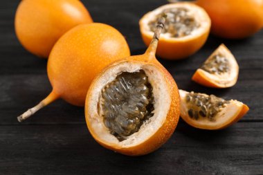 Lezzetli olgun granadillalar siyah ahşap masada, yakın plan