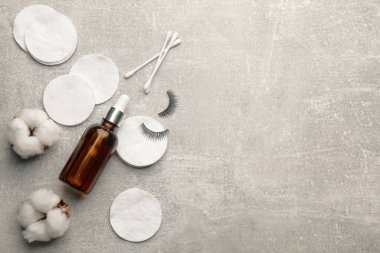 Pamuk pedler, bezler ve makyaj malzemesi gri masada, düz yerde. Metin için boşluk