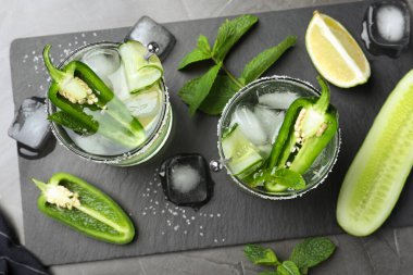 Baharatlı kokteyl, jalapeno, salatalık ve limon siyah masada.