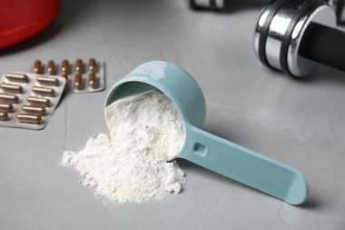 Açık gri masada bir kepçe amino asit tozu ölçülüyor.