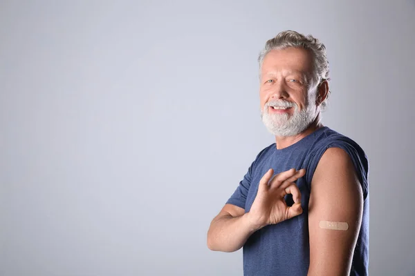 Cheerful Senior Man Showing Arm Bandage Vaccination Grey Background Space — Stock Photo, Image