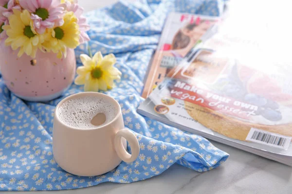 Tasse Frischer Kaffee Schöner Strauß Und Zeitschriften Auf Hellblau Bedrucktem — Stockfoto