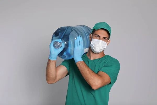 Courier Medical Mask Holding Bottle Water Cooler Light Grey Background — Stock Photo, Image
