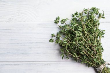Beyaz ahşap masada bir demet aromatik kekik, üst manzara. Metin için boşluk