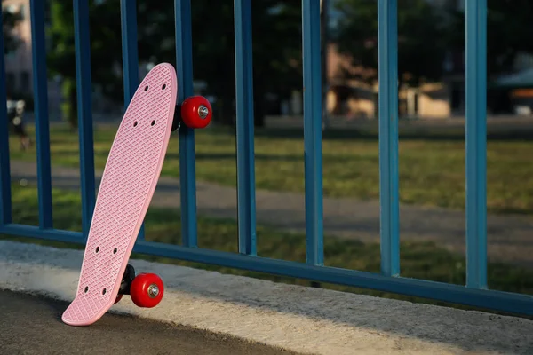 Modern Roze Skateboard Buurt Van Hek Buiten Ruimte Voor Tekst — Stockfoto