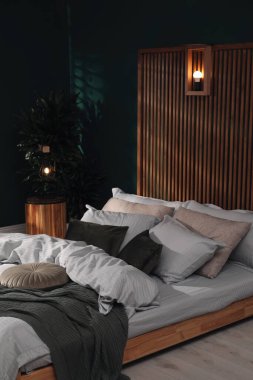 Geniş konforlu yatağı ve saksısı olan şık bir iç mekan.