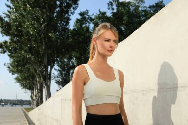 Güneşli bir günde dışarıda spor giyim sektöründe güzel bir kadın.