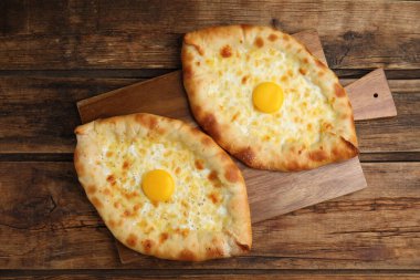 Tahta masada peynirli ve yumurtalı taze ev yapımı khachapuri.