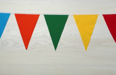 Beyaz ahşap arka planda renkli üçgen bayraklar