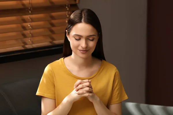 Religiös Ung Kvinna Med Knäppta Händer Ber Inomhus — Stockfoto