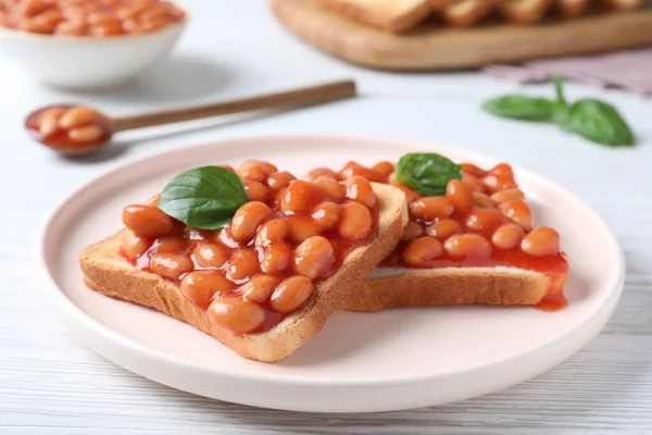 Rostat Bröd Med Delikata Konserverade Bönor Vitt Träbord — Stockfoto