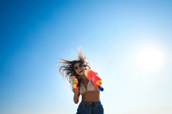 青い空に対して水銃を持つアフリカ系アメリカ人女性 低角度ビュー — ストック写真
