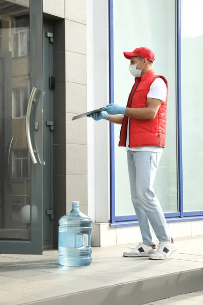 Kurier Medizinischer Maske Mit Klemmbrett Und Flasche Für Wasserkühler Entbindung — Stockfoto