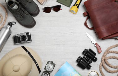 Beyaz ahşap arka planda safari aksesuarları çerçevesi, üst manzara. Metin için boşluk