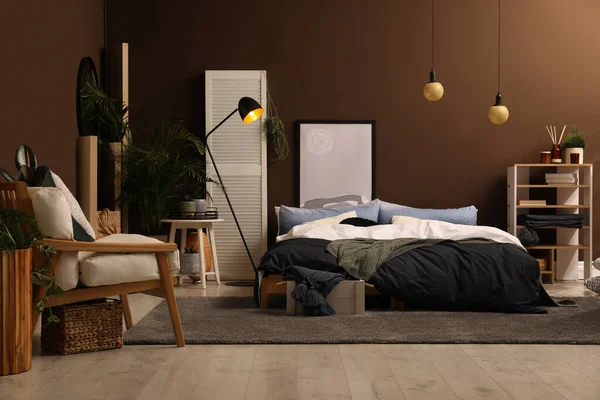 茶色の壁の近くに大きなベッドとスタイリッシュな部屋のインテリア — ストック写真