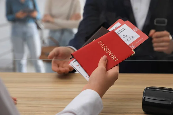 在机场办理登机手续时 特勤人员向客户提供附有机票的护照 — 图库照片