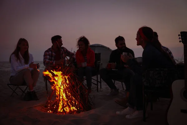 Ομάδα Φίλων Μαζεύονται Γύρω Από Φωτιά Στην Παραλία Βράδυ Περίοδος — Φωτογραφία Αρχείου