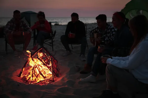 Bir Grup Arkadaş Akşam Sahilde Şenlik Ateşi Etrafında Toplanıyor Kamp — Stok fotoğraf