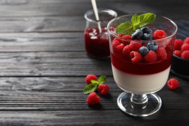 Siyah ahşap masada böğürtlenli lezzetli panna cotta. Metin için boşluk