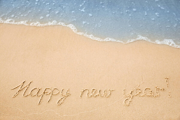 Sandy beach with text Happy New Year washed by sea, above view