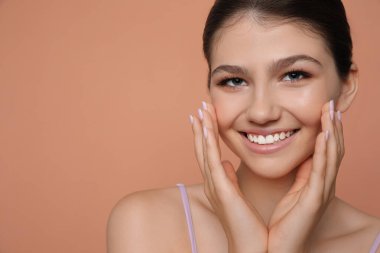 Soluk mercan arka planda güzel bir kız, mesaj için yer var. Güzel bir yüz, pürüzsüz bir ten.