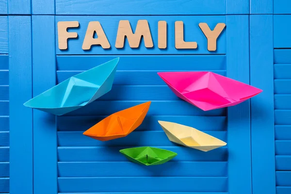 Papierschiffe Und Wort Familie Auf Blauem Holzgrund Flach Gelegt — Stockfoto