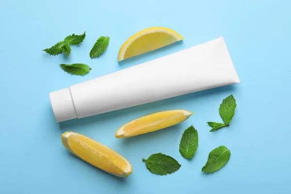Leere Tube Zahnpasta Mit Minzblättern Und Zitronenscheiben Auf Türkisfarbenem Hintergrund — Stockfoto
