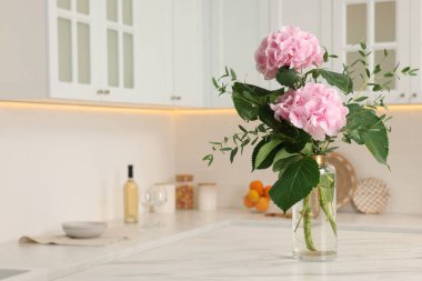 Mutfak masasındaki vazoda duran güzel pembe hortensiya çiçekleri. Metin için boşluk