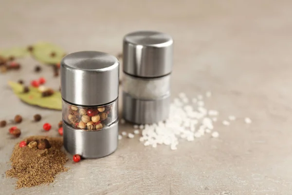 Salt and pepper shakers on light grey table, closeup. Space for text