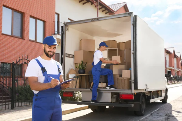 Moving Service Workers Outdoors Unloading Boxes Checking List — Stock Photo, Image