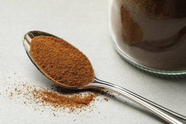 Açık gri masada hindiba tozu kaşığı, yakın plan.