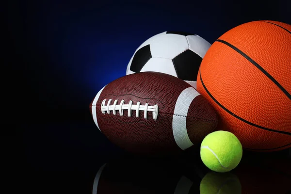 ブラックミラー表面に異なるスポーツボールのセット — ストック写真