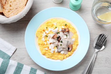 Banosh hafif ahşap masada brynza ve mantarla servis edilir. Geleneksel Ukrayna yemeği