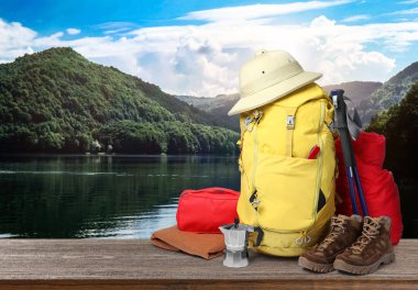 Ahşap yüzeyde turistler için kamp malzemeleri ve güzel dağ manzarası.