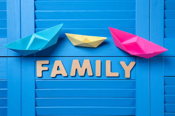 Χάρτινα Πλοία Και Λέξη Οικογένεια Μπλε Ξύλινο Φόντο Επίπεδη Lay — Φωτογραφία Αρχείου