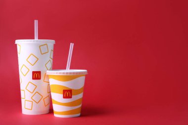 MYKOLAIV, UKRAINE - 12 Ağustos 2021: soğuk McDonald 's içkileri kırmızı arka planda. Metin için boşluk