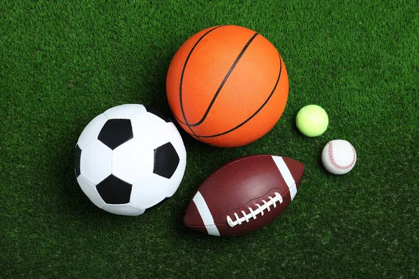 緑の芝生の上で異なるスポーツボールのセット フラットレイアウト — ストック写真