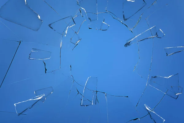 青い背景に亀裂が入った壊れたガラス — ストック写真