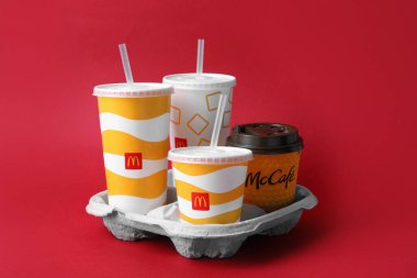 MYKOLAIV, UKRAINE - 12 Ağustos 2021: Kırmızı arka planda soğuk ve sıcak McDonald 's içecekleri