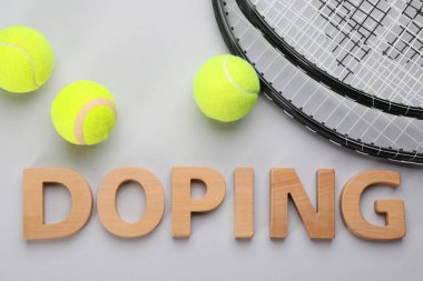 Kelime Doping, tenis raketleri ve toplar açık gri arka planda, düz yatıyordu