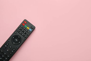 Pembe arka planda uzaktan kumanda, üst görünümde. Metin için boşluk