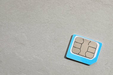 Açık gri taş zemin üzerinde mikro SIM kart, üst görünüm. Metin için boşluk