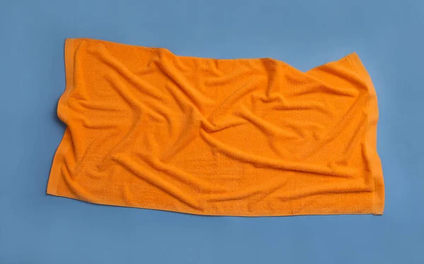 蓝色背景的折皱橙色沙滩毛巾 顶视图 — 图库照片
