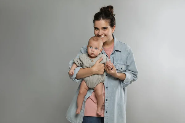 Hermosa Madre Con Lindo Bebé Sobre Fondo Gris Espacio Para —  Fotos de Stock