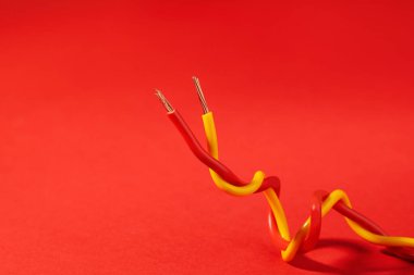 Kırmızı arka planda iki farklı elektrik kablosu. Metin için boşluk