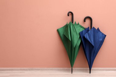 Bej duvarın yakınındaki kapalı parlak şemsiyeler. Metin için boşluk