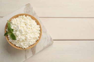 Beyaz ahşap masada fesleğenli nefis taze süzme peynir, üst manzara. Metin için boşluk