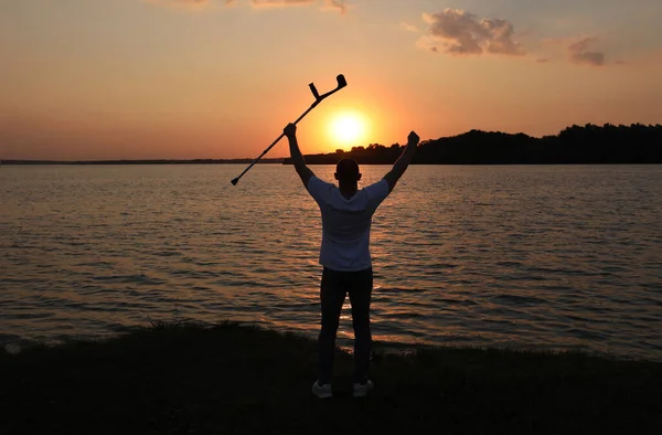 Man Verhoogt Elleboog Kruk Naar Hemel Bij Zonsondergang Achteraanzicht Genezingswonder — Stockfoto