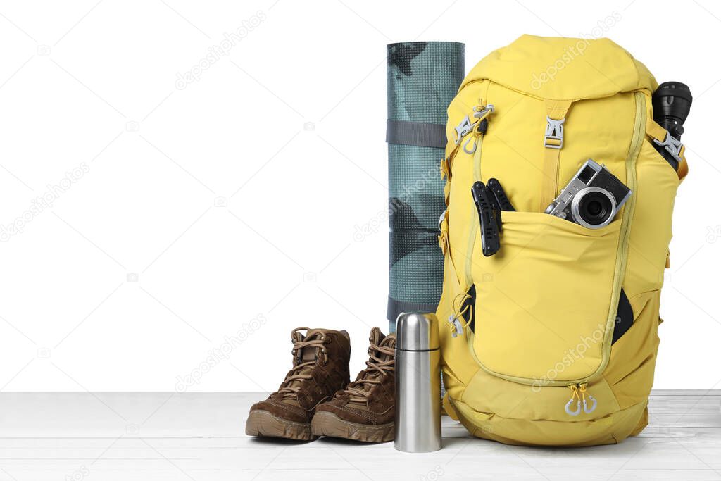 Set of tourist equipment on wooden surface against white background. Space for text